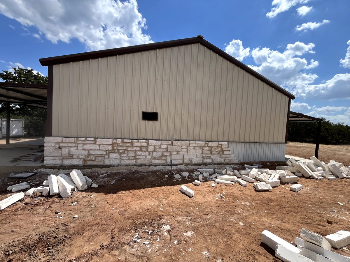 Stone masonry in Hamilton County, Texas — finished limestone wainscot on a metal building by WhiteStone Construction