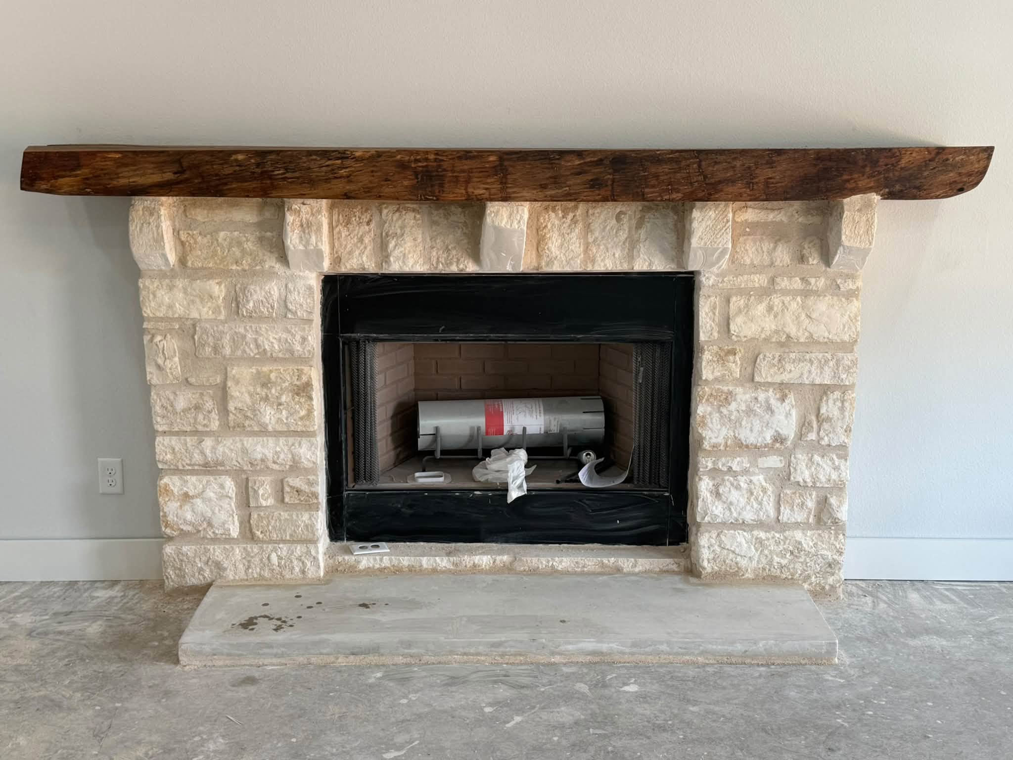 Stone fireplace with a natural pecan mantle built by WhiteStone Construction for Rick Toumbs in Evant, Texas